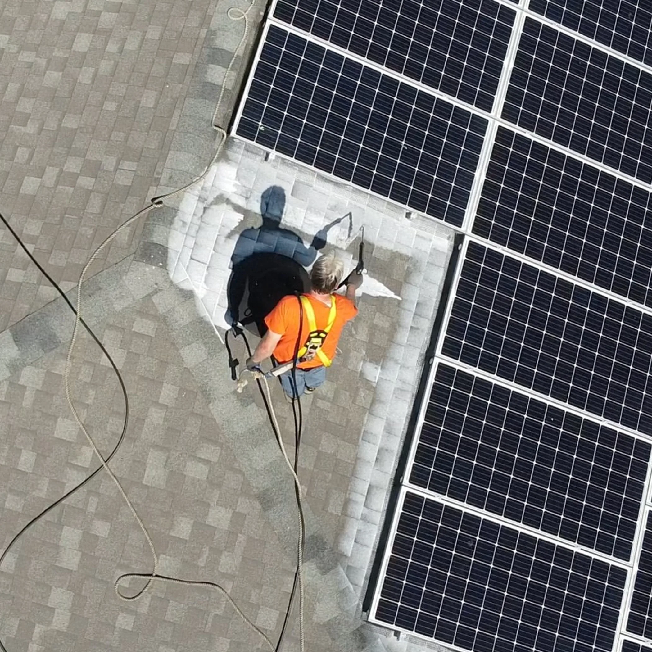 worker maintaining roof with solar panels
